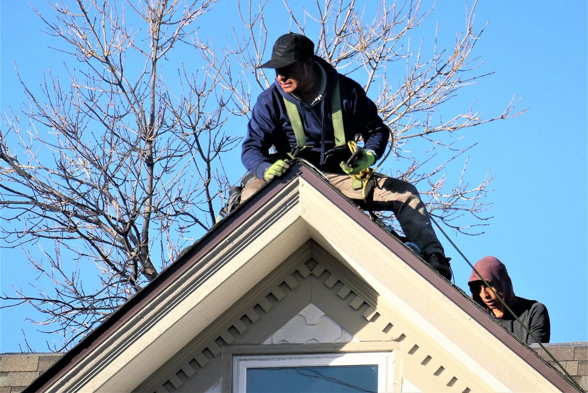Roofing crew working on a pitched roof